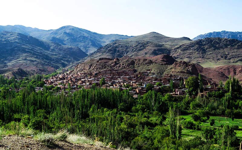 روستای سرخ ابیانه میان کوهستان و درختان سبز