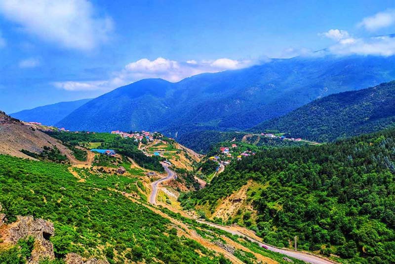 مسیر کوهستانی روستای جواهرده زیر آسمان آبی از نمای بالا